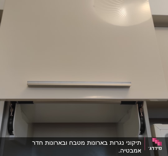 ארון מטבח עם דלת פתוחה ומנגנון הרמה